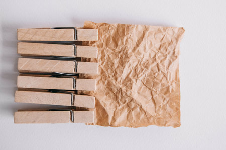 Woodenl clothespins, paper clip and brown sticker on white background. Isolated on white. View from above. Place for your textの写真素材