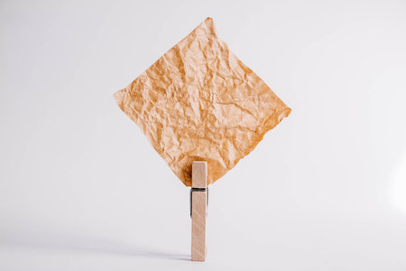 Brown sticker with wooden clothespin isolated on white background. Place for your textの写真素材