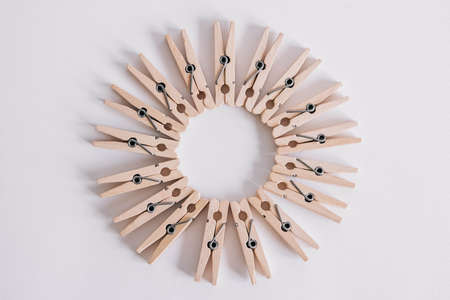 Group of wooden clothespins arranged in a circle isolated on white background. Copy spaceの写真素材