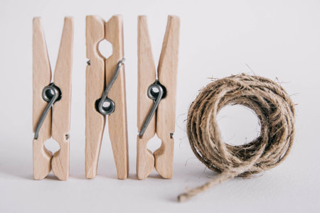 Wooden clothespins with rope on white background. Place for your textの写真素材