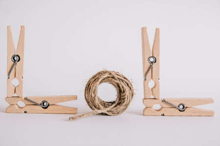 Wooden clothespins with rope on white background. Place for your textの写真素材