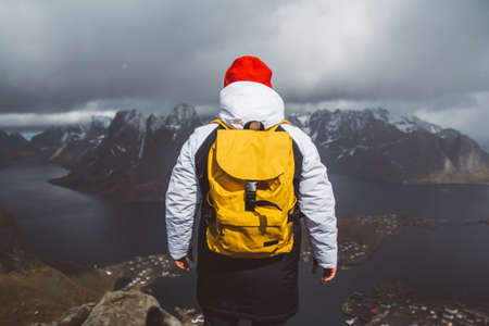 Man traveler hiking on Reinebringen mountain ridge in Norway lifestyle adventure travelingの写真素材