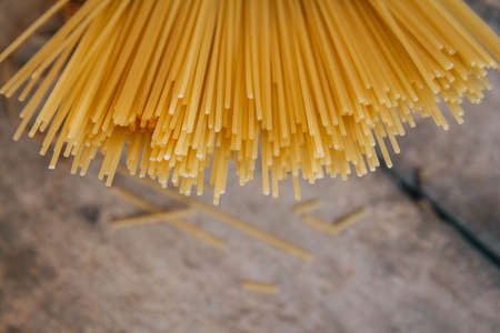 Yellow long spaghetti on an old wooden background. Food concept background. Top view. Copy, empty space for text.の写真素材