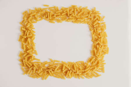 Spiral pasta on a white background forming a frame around. Top view. Copy, empty space for text.の写真素材