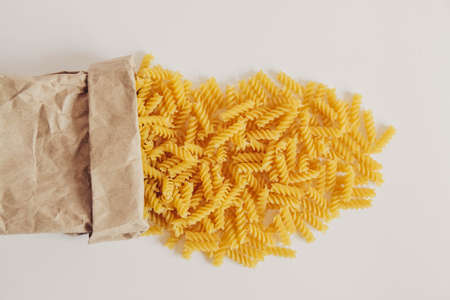 Spiral pasta in a paper bag on a white background. Top view. Copy, empty space for textの写真素材