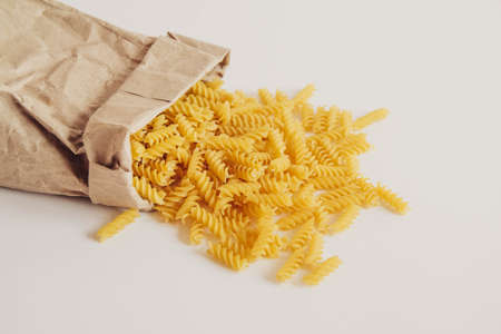 Spiral pasta in a paper bag on a white background. Top view. Copy, empty space for textの写真素材