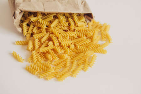 Spiral pasta in a paper bag on a white background. Top view. Copy, empty space for textの写真素材
