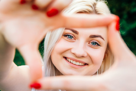 Beautiful blonde girl in headphones and smartphone in hands listens to music lying on green background. Lifestyle concept. Copy, empty space for text.の写真素材