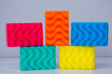Plastic bottle and sponges for washing dishes on a white table. Cleaning equipment. Space for text.の写真素材