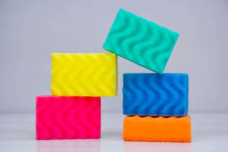 Multicolored sponges for cleaning and washing dishes on a blue background. Space for text.の写真素材