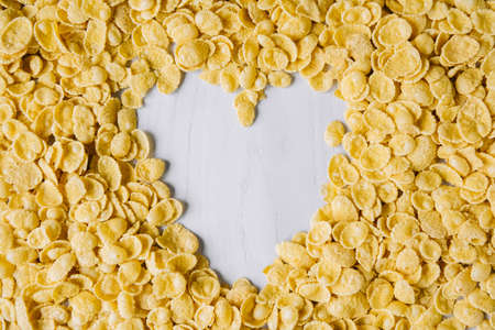 Corn flakes in a glass jar on white wooden surface. Place for your text.の写真素材