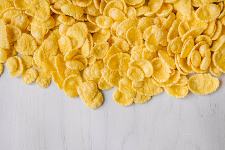 Corn flakes in a glass jar on white wooden surface. Place for your text.の写真素材