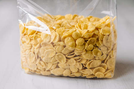 Corn flakes in a glass jar on white wooden surface. Top view. Place for your text.の写真素材