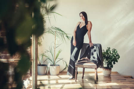 Beautiful girl model dressed in black clothes in Loft style interior.