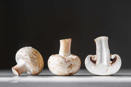 Mushrooms champignons in paper bag on a white wooden table. Place for text or advertising.の写真素材