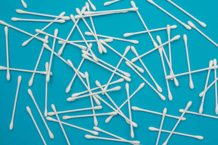 Cotton pads, plastic bottle and cotton buds on blue background. Spa concept. Cotton Cosmetic Makeup Removers Tampons. Top view. Copy, empty space for text.の写真素材