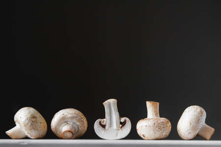 Mushrooms champignons in paper bag on a white wooden table. Place for text or advertising.の写真素材