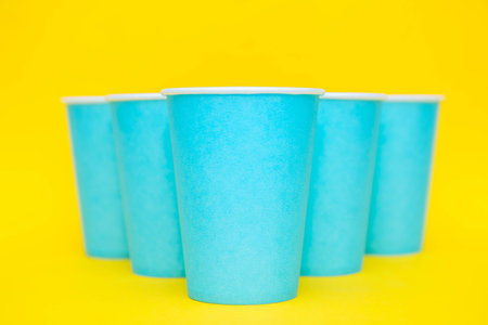 White plastic spoon on blue and yellow background. Top view. Copy, empty space for text.