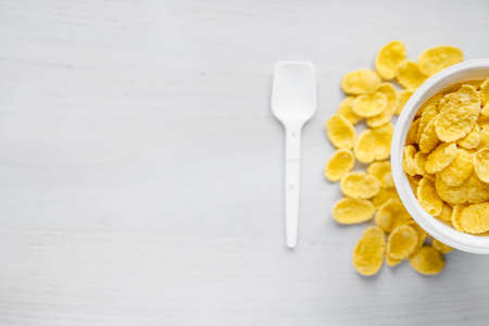 White plastic spoon on blue and yellow background. Top view. Copy, empty space for text.の写真素材