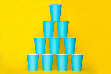 Yellow rubber glove for cleaning hang on blue background. Top view. Minimalist Style. Copy, empty space for text.の写真素材