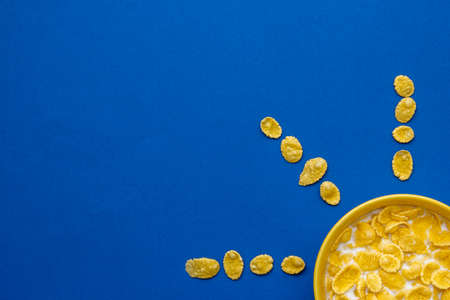 Pattern from blue paper disposable cups on yellow background. Set for party. Top view. Minimalist Style. Copy, empty space for text.の写真素材