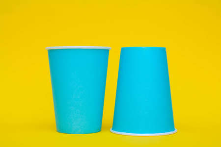 Many blue paper cups on orange background. Set for party. Copy, empty space for text.の写真素材