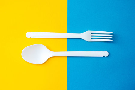 Pyramid of blue paper disposable cups on yellow background. Set for party. Copy, empty space for...