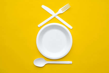 Pyramid of blue paper disposable cups on yellow background. Set for party. Copy, empty space for text.の写真素材