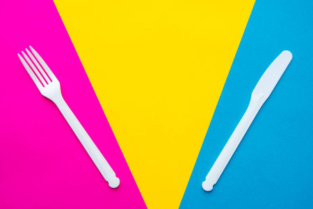 Pyramid of blue paper disposable cups on yellow background. Set for party. Copy, empty space for text.の写真素材