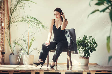 Beautiful girl model dressed in black clothes in Loft style interior.の写真素材