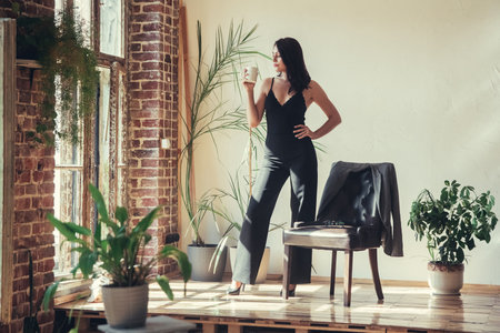 Beautiful girl model dressed in black clothes in Loft style interior.の写真素材
