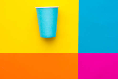 Blue paper cups with drinking colored plastic straws on beautiful multicolored background. Set for party. Top view. Minimalist Style. Copy, empty space for text.の写真素材