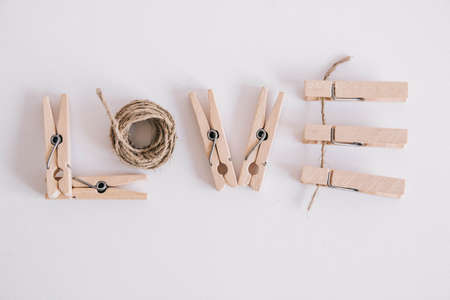 Wooden clothespins in paper bag with rope on white background. Place for your text.の写真素材