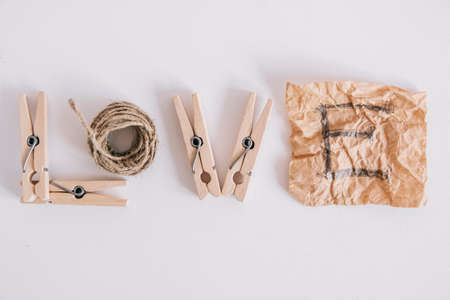 Wooden clothespins in paper bag with rope on white background. Place for your text.の写真素材