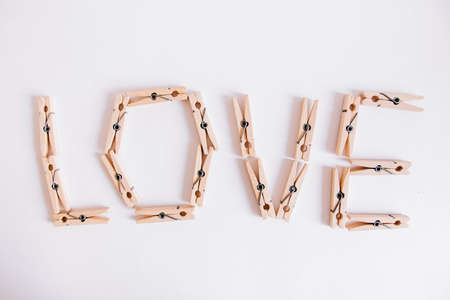 Wooden clothespins in paper bag with rope on white background. Place for your text.の写真素材
