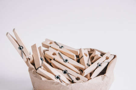 Wooden clothespins in paper bag with rope on white background. Place for your text.の写真素材