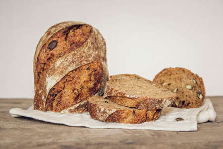 Brown fresh bread with seeds on old wood background. Top view, copy space.の写真素材