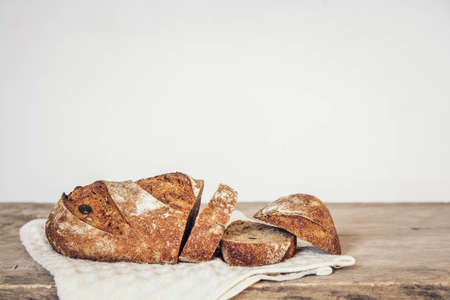 Brown fresh bread with seeds on old wood background. Top view, copy space.の写真素材