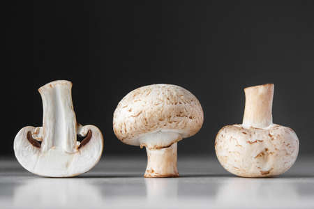 Mushrooms champignons in paper bag on a white wooden table. Place for text or advertising.の写真素材