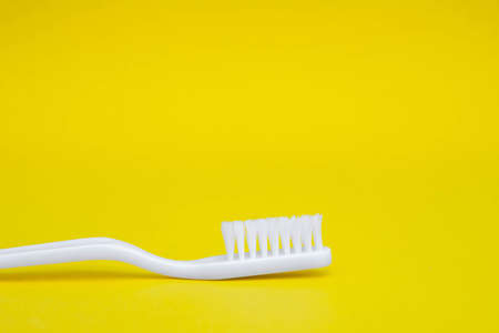 Plastic white fork, knife and spoon in the form of a triangle on yellow background. Cooking utensil. Top view. Minimalist Style. Copy, empty space for text.の写真素材