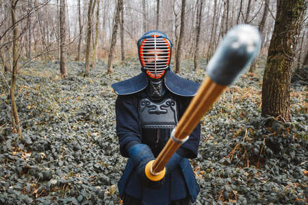 Man practicing kendo with shinai bamboo sword on forest background. Place for text or advertising.の写真素材