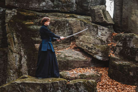 Man practicing kendo with shinai bamboo sword on forest background. Place for text or advertising.の写真素材