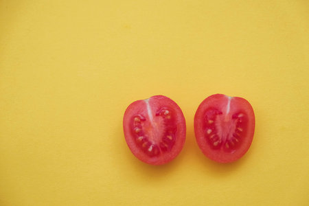 Red tomatos vegetable on a yellow background. Top view. Minimalist Style. Copy, empty space for...