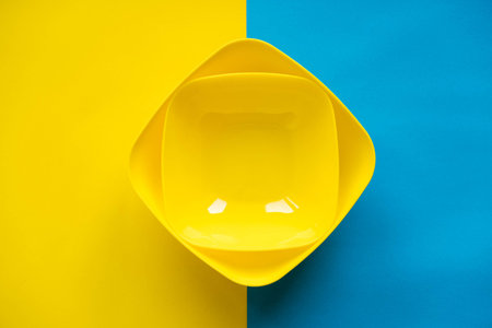 Yellow plastic building blocks on blue and yellow background. Pieces and elements of constructor....