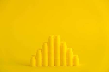 Yellow plastic building blocks on blue and yellow background. Pieces and elements of constructor. Parts of bright small spare parts for toys. Top view. Copy, empty space for text.の写真素材