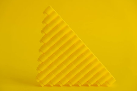Yellow plastic building blocks on yellow background. Background of plastic details building blocks. Parts of bright small spare parts for toys. Top view. Copy, empty space for text.の写真素材