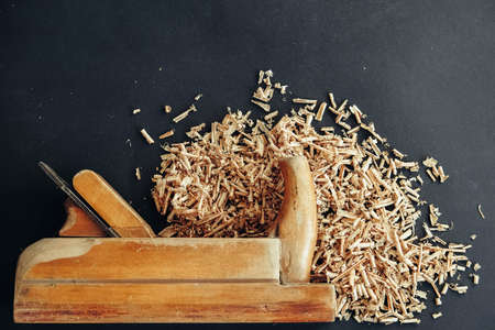 Wood drill bit with wooden shavings on black background. Copy, empty space for text.の写真素材