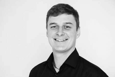 Portrait of a young man smiling on a white background. Black-white photo. Copy, empty space for text.の写真素材