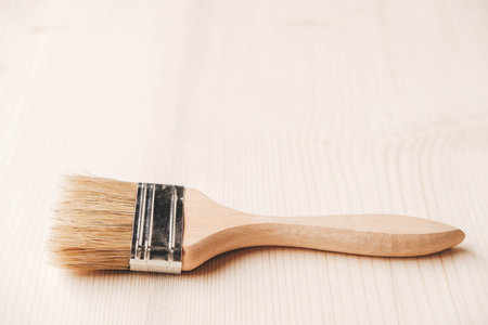 Paint brushes with a wooden handle and natural bristles on a wooden background. Repair concept....
