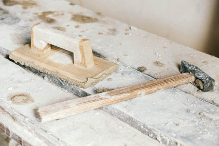 Old construction tools for plaster on vintage wood bench. Trowels and other masonry tools. Copy,...